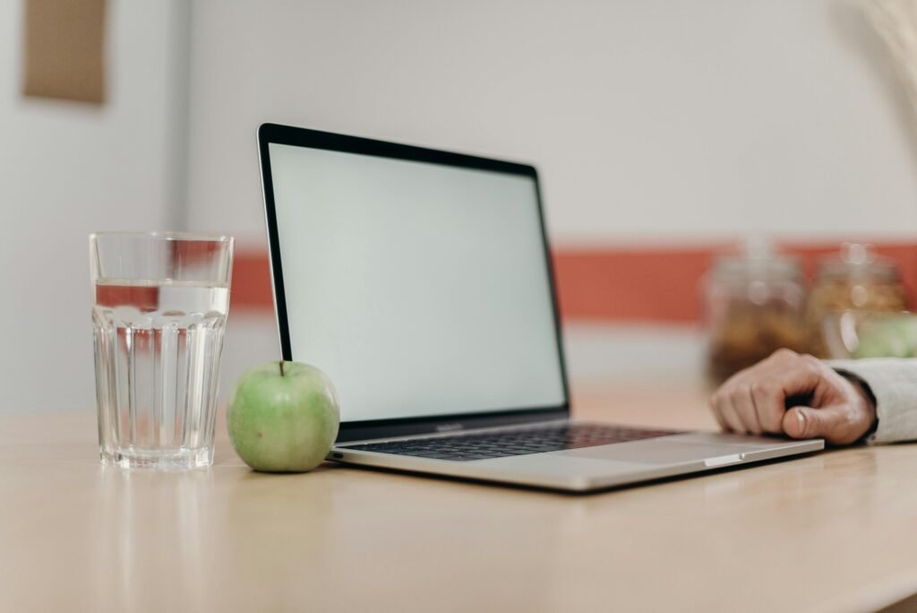 Green Apple Fruit Beside Black Tablet Computer on Brown Wooden Table